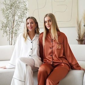 two women sitting on a couch in matching pajamas