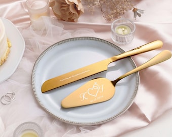 May include: A gold-toned cake knife and server set resting on a light gray plate. The knife is engraved with the text Love you to the moon and back. The server features an engraved heart, a ring icon, the letters K and J, and the date 01.12.2026.
