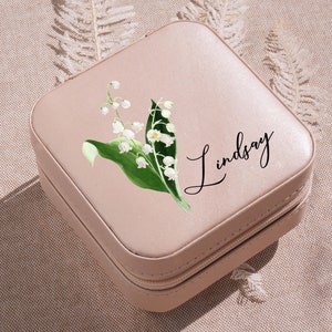 a small pink box with a picture of a lily of the valley on it