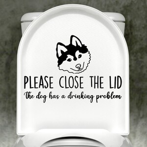 May include: White toilet seat with a black and white husky dog illustration and the text "PLEASE CLOSE THE LID The dog has a drinking problem."
