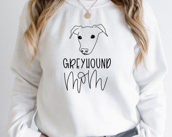 May include: White sweatshirt with a black line drawing of a Greyhound dog and the text "Greyhound Mom" in black.
