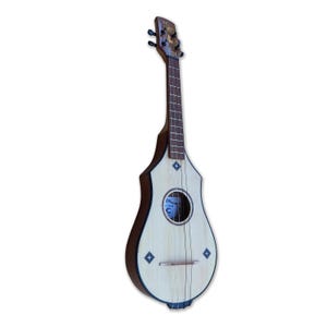 Peut inclure: Un instrument à cordes de couleur claire avec un corps et un manche en bois. L'instrument possède une rosace ronde et quatre cordes. Des incrustations décoratives en forme de losange sont visibles sur le corps. La tête est marron foncé avec des chevilles d'accord.