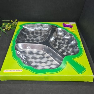 May include: A triple chrome-plated serving tray with three sections, in a green leaf-shaped box. The tray features a checkered pattern, suitable for snacks or appetizers. The box has the text "triple chrome plated".