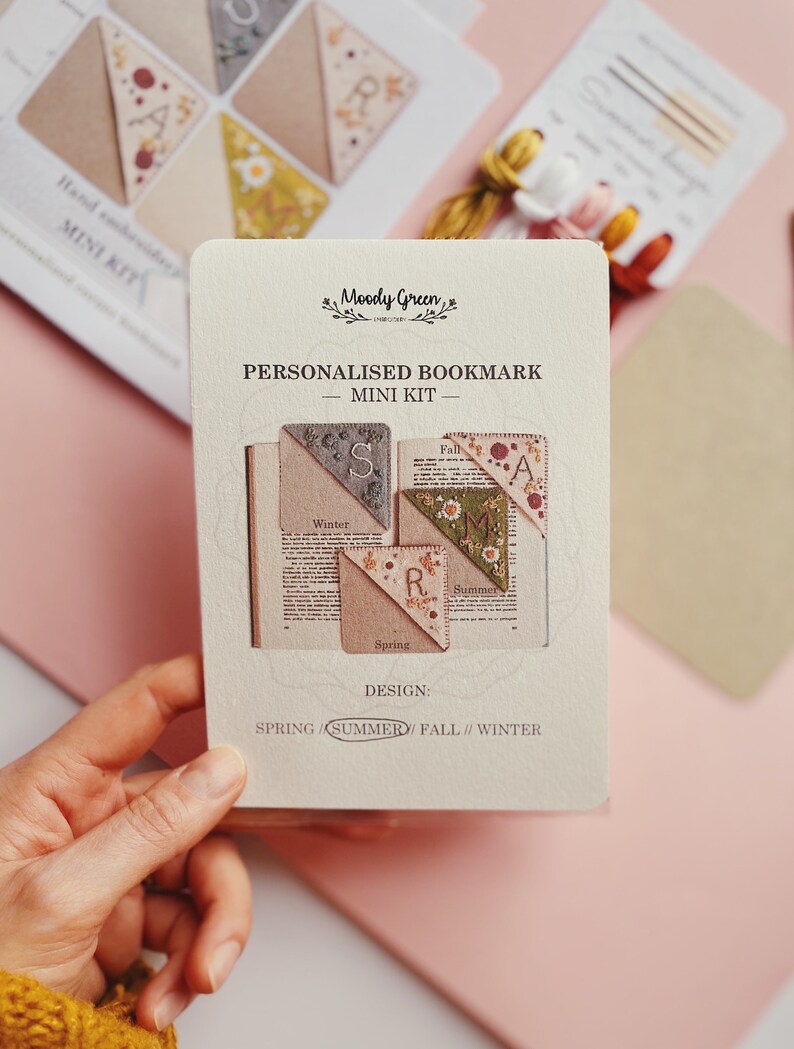 May include: A set of four personalized bookmark mini kits. Each kit features a different season: Spring, Summer, Fall, and Winter. The kits are made of fabric and feature embroidered details. The text on the card reads "Personalized Bookmark - Mini Kit - Design: Spring/Summer/Fall//Winter".