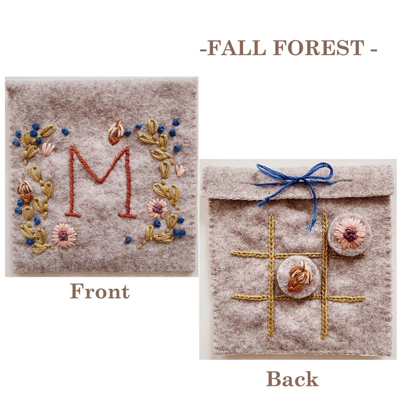 May include: A grey felt pouch with a front embroidered with a floral design and the letter "M" in red. The back of the pouch has a noughts and crosses board embroidered with brown thread and two felt circles.