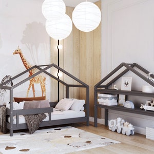 May include: A gray wooden house-shaped bed frame with a gray mattress and a gray blanket. The bed is decorated with pillows and a throw blanket. There is a gray wooden shelf unit with two shelves and a panda bear print on the wall.