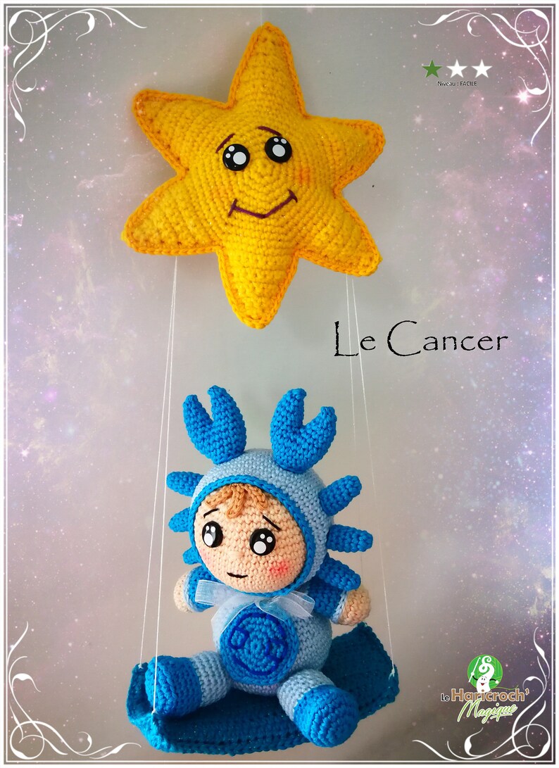 Pode incluir: Um caranguejo azul de croch&ecirc; vestindo um traje azul e branco com uma estrela azul no peito. O caranguejo est&aacute; pendurado em uma estrela amarela com um rosto sorridente. O texto "Le Cancer" est&aacute; escrito abaixo do caranguejo.