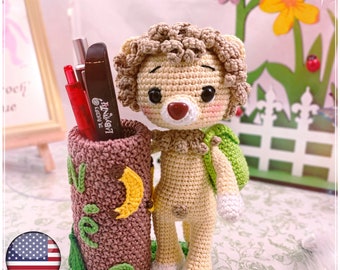 Może przedstawiać: Pluszowy jeż amigurumi trzymający ołówek. Ołówek jest wykonany z brązowego i zielonego materiału i ma wzór księżyca i gwiazd. Jeż ma na sobie zielony plecak i ma brązowy nos i białe łapy.