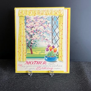 Peut inclure: Une carte d'anniversaire vintage pour Maman, représentant une scène de fenêtre avec un arbre en fleurs et des tulipes dans un pot bleu. La carte a des rideaux jaunes à pois rouges et le texte "Mother dear, May your window open to sunshine on your Birthday morn."