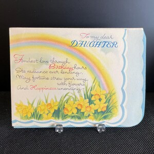 May include: A vintage birthday card for a daughter, featuring a rainbow, daffodils, and text. The card has a light blue scalloped edge and includes the words "To my dear DAUGHTER" and a poem about love and happiness.