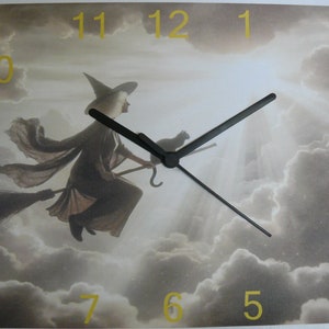 May include: A square clock with a witch flying on a broomstick in front of a cloudy sky. The clock face has black hands and gold numbers 1 through 12.