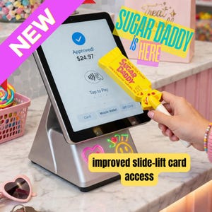 Puede incluir: Un sistema de pago con tableta plateada muestra una transacción aprobada de $24.97. Un lector de tarjetas "Sugar Daddy" amarillo se sostiene cerca de la pantalla. La imagen incluye el texto "NEW", "SUGAR DADDY IS HERE" y "improved slide-lift card access".