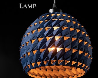Puede incluir: Una lámpara colgante azul marino con un diseño geométrico. La lámpara tiene forma esférica con recortes triangulares que revelan un brillo naranja cálido. El texto "TRIOS PENDANT LAMP" está en la parte superior de la imagen.