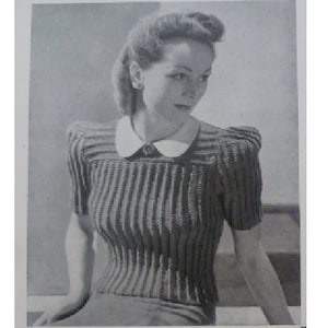 Puede incluir: Una foto en blanco y negro de una mujer con un suéter de punto con hombros abullonados y un cuello blanco. El suéter tiene una textura acanalada.