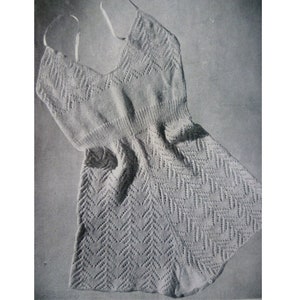 Puede incluir: Un vestido blanco de punto sin mangas con un patrón geométrico. El vestido tiene un escote redondo y un corpiño ajustado. La falda es acampanada y llega a la mitad del muslo.