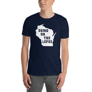 May include: Navy blue t-shirt with the white outline of Wisconsin and the text "BRING ON THE LEFSE". The shirt is made of a soft material.