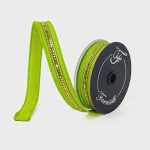 May include: A spool of lime green ribbon with gold and green embellishments. The ribbon is made of a soft, textured material and is labeled "Farrisilk" on the spool.