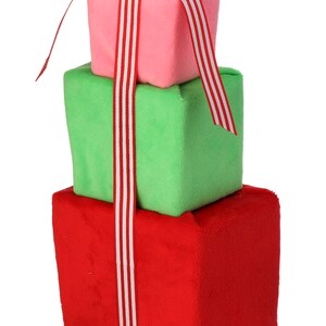 Può includere: Una pila di tre scatole regalo in peluche legate con un nastro a righe rosso e bianco. La scatola superiore è rosa, la scatola centrale è verde e la scatola inferiore è rossa.