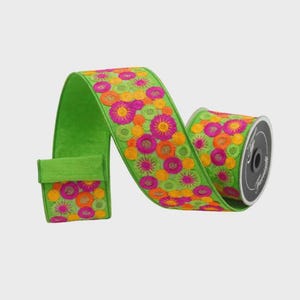May include: A roll of bright green ribbon with a floral pattern in shades of pink, orange, and yellow. The ribbon is embroidered with a repeating design of stylized flowers. The spool is black with white text.