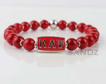 Kappa Alpha Psi Fraternity Stretch Bead Bracelet: KAΨ center bead paired with silver tone & crimson coral beads. Perfect gift for a Nupe!