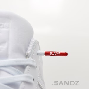 Kappa Alpha Psi shoelaces. Polyester with metal aglet with embossed Kappa Alpha Psi greek letters. 2 0ptions: White laces / Red Laces
