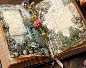 Könnte beinhalten: Ein offenes antikes Buch mit floralen Illustrationen und einem Schleifen-Lesezeichen. Die Seiten zeigen Gartenszenen und gealterte Papierstrukturen. Frische Blumen, darunter eine rosa Zinnie und eine Pfirsichrose, sind in der Nähe des Buches angeordnet.