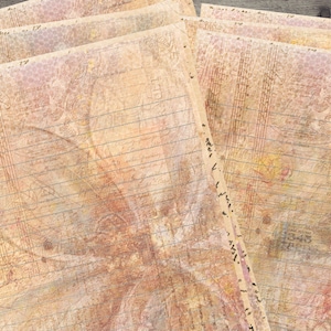 Op de afbeelding: Een stapel vintage-stijl gelinieerd papier met een vervaagd bloemenontwerp en een textuur achtergrond.