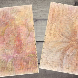 Op de afbeelding: Twee vintage-stijl papieren vellen met gelinieerd schrijfpapier en een vervaagd bloemenontwerp. Het papier heeft een textuur, een verouderde uitstraling met een subtiel honingraatpatroon.
