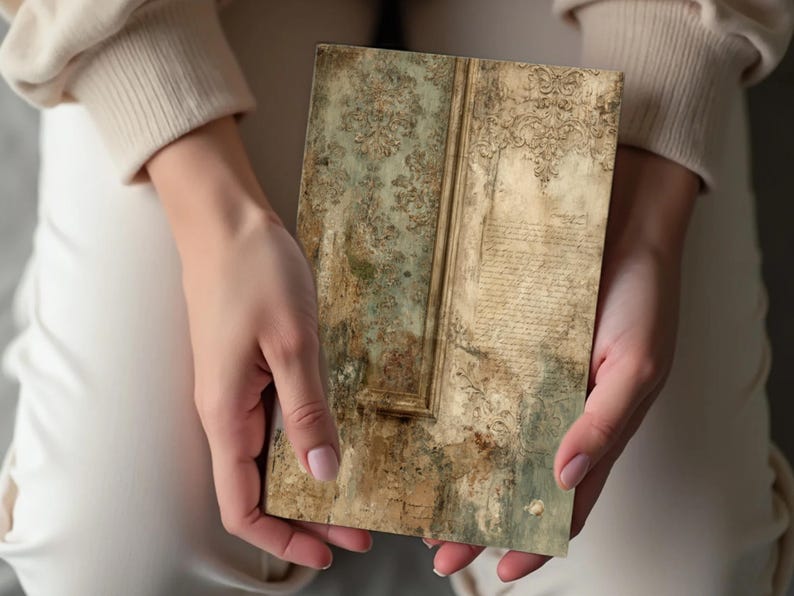 May include: A rectangular, vintage-style decorative panel with a distressed, aged appearance. The panel features a faded green and brown color scheme with ornate floral patterns and script-like text. The panel is held by a person.