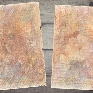Op de afbeelding: Twee vellen textuurpapier met een rasterpatroon en vervaagde aquarelwas in tinten roze, oranje en geel. Het papier heeft een vintage uitstraling en gevoel.
