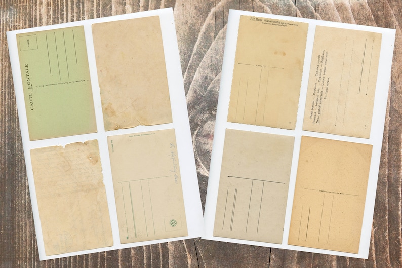 May include: Eight vintage postcards with blank spaces for writing messages. The postcards are on a wooden surface.