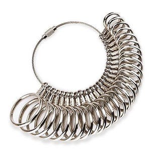 May include: A silver ring sizer with a chain and a series of graduated rings. The rings are numbered from 1 to 30.