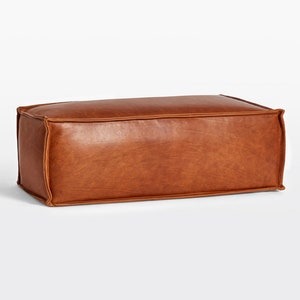 May include: A white ceramic mug with a black handle and the text "But First, Coffee" in a bold, black font. The mug is set against a blurred background, suggesting a cozy setting. The mug appears to be approximately 4 inches tall.