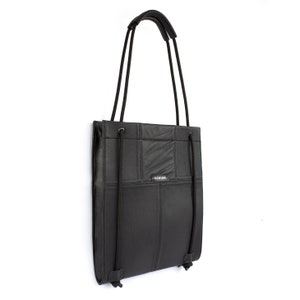 Könnte beinhalten: Schwarze Ledertasche mit einem Logo mit der Aufschrift "MINIKKI" auf der Vorderseite. Die Tasche hat einen oberen Griff und zwei verstellbare Träger, die als Rucksack getragen werden können.