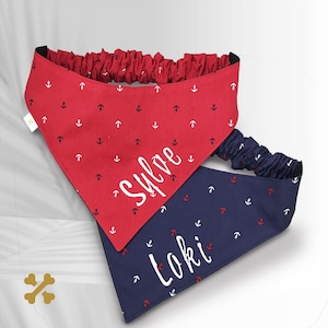 May include: Two pet bandanas with elastic neckbands. One is red with a white anchor pattern and the name "Sylve" in white script. The other is navy blue with a red and white anchor pattern and the name "Loki" in white script. Both feature triangular fabric.