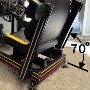 Op de afbeelding: Een zwarte en gele racesimulator met een stuur, pedalen en meerdere schermen. De stoel is zwart met gele accenten. Een toetsenbord en andere bedieningselementen zijn op het zwarte frame gemonteerd, met rode, gele en oranje strepen.