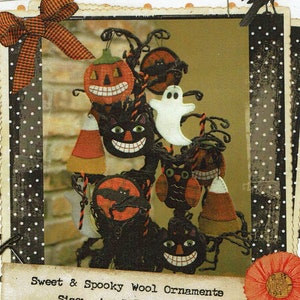 May include: A collection of felt Halloween ornaments hanging on a branch. The ornaments include a pumpkin, a ghost, a black cat, an owl, and a bat. The ornaments are all decorated with spooky faces and details.