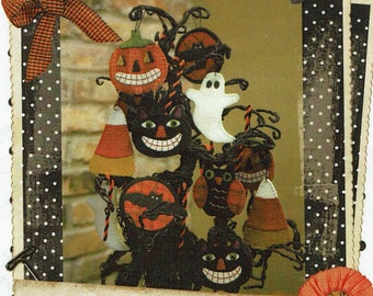 May include: A collection of felt Halloween ornaments hanging on a branch. The ornaments include a pumpkin, a ghost, a black cat, an owl, and a bat. The ornaments are all decorated with spooky faces and details.