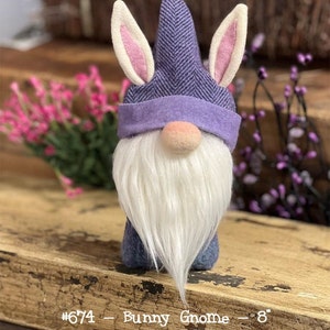 May include: Purple and pink bunny gnome with a white beard. The gnome is 8 inches tall. #674 - Bunny Gnome - 8"