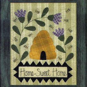 Puede incluir: Una obra de arte enmarcada con una colmena, flores moradas y abejas. La obra de arte tiene un borde festoneado en blanco y negro con el texto "Home Sweet Home".