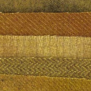 May include: Close-up of a fabric swatch featuring various textured sections. The colors range from muted greens and browns to warm golds and tans. The textures include herringbone and other woven patterns.