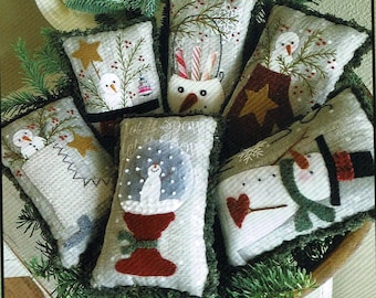 May include: A set of six handmade felt Christmas ornaments featuring snowmen in various winter scenes. The ornaments are decorated with embroidery and have a rustic, vintage style.