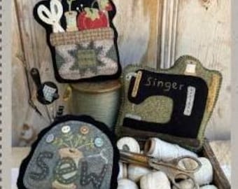 May include: Three handmade felt pillows with a sewing theme. The first pillow is a basket with sewing supplies, the second pillow is a vintage sewing machine, and the third pillow has the word "Sew" embroidered on it.