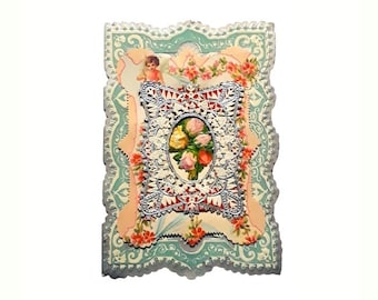 Puede incluir: Una tarjeta vintage de San Valentín con un delicado diseño de encaje y un motivo floral. La tarjeta está en tonos de rosa, azul y blanco.