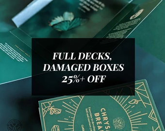 May include: A green card deck box with gold accents and the text "Chrysall Breaker" and "Exercises to develop a strong self and nurture your inner wisdom". The box is on a stack of other green boxes with the text "Full Decks, Damaged Boxes 25%+ Off".