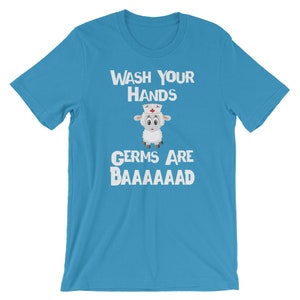 May include: A light blue t-shirt featuring a white sheep wearing a nurse's hat. The text "WASH YOUR HANDS GERMS ARE BAAAAAAAAD" is printed on the shirt.
