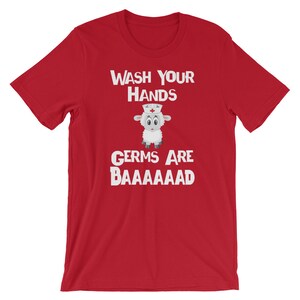 May include: Red short-sleeved t-shirt with white text that reads "Wash Your Hands" and "Germs Are Baaaaaaad". A cartoon sheep wearing a nurse's hat is in between the text.