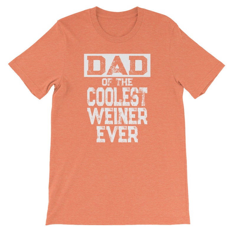 May include: Orange short-sleeved t-shirt with white text that reads "DAD OF THE COOLEST WEINER EVER".