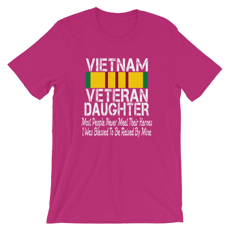 May include: Pink t-shirt with a white graphic that says "VIETNAM VETERAN DAUGHTER" with a yellow and green ribbon. The text below the graphic says "Most People Never Meet Their Heroes I Was Blessed To Be Raised By Mine."