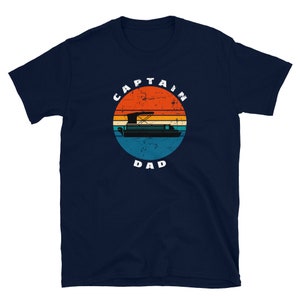 May include: Navy blue t-shirt with a retro sunset graphic featuring a pontoon boat and the text "Captain Dad".